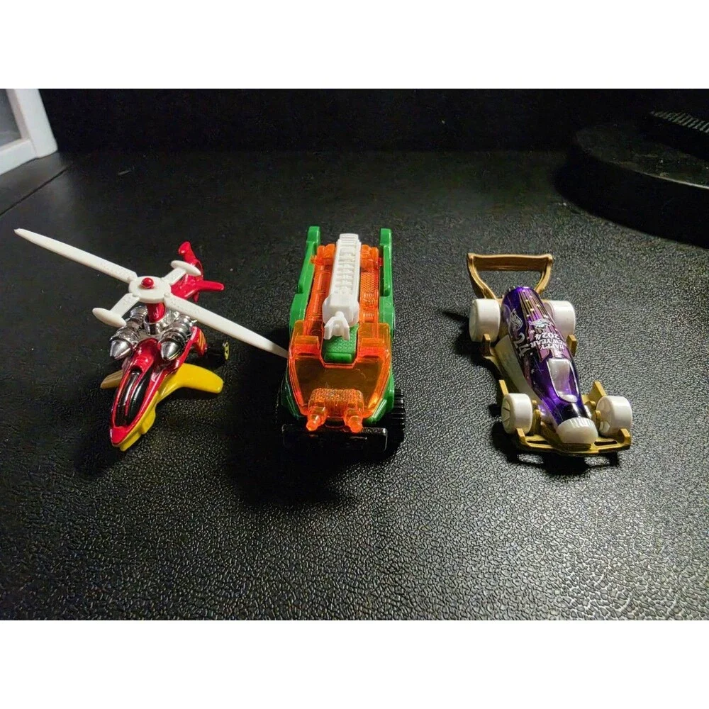 Lot of 4 loose Hot Wheels vehicles in pre-owned condition.
